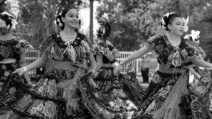 Two girls in hispanic dresses performing a dance